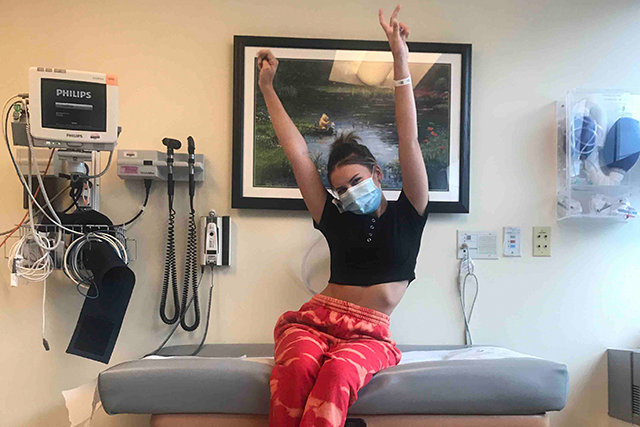 Ava strikes a triumphant pose after successfully completing treatment at the Center for Cancer & Blood Disorders.