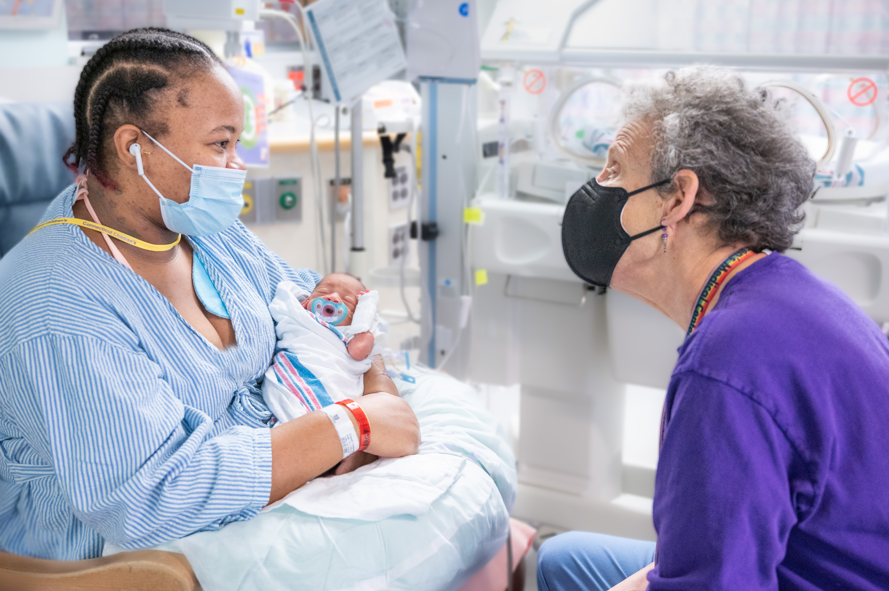 Dr. Sanders speaking with a mother who is holding her infant while in the NICU.