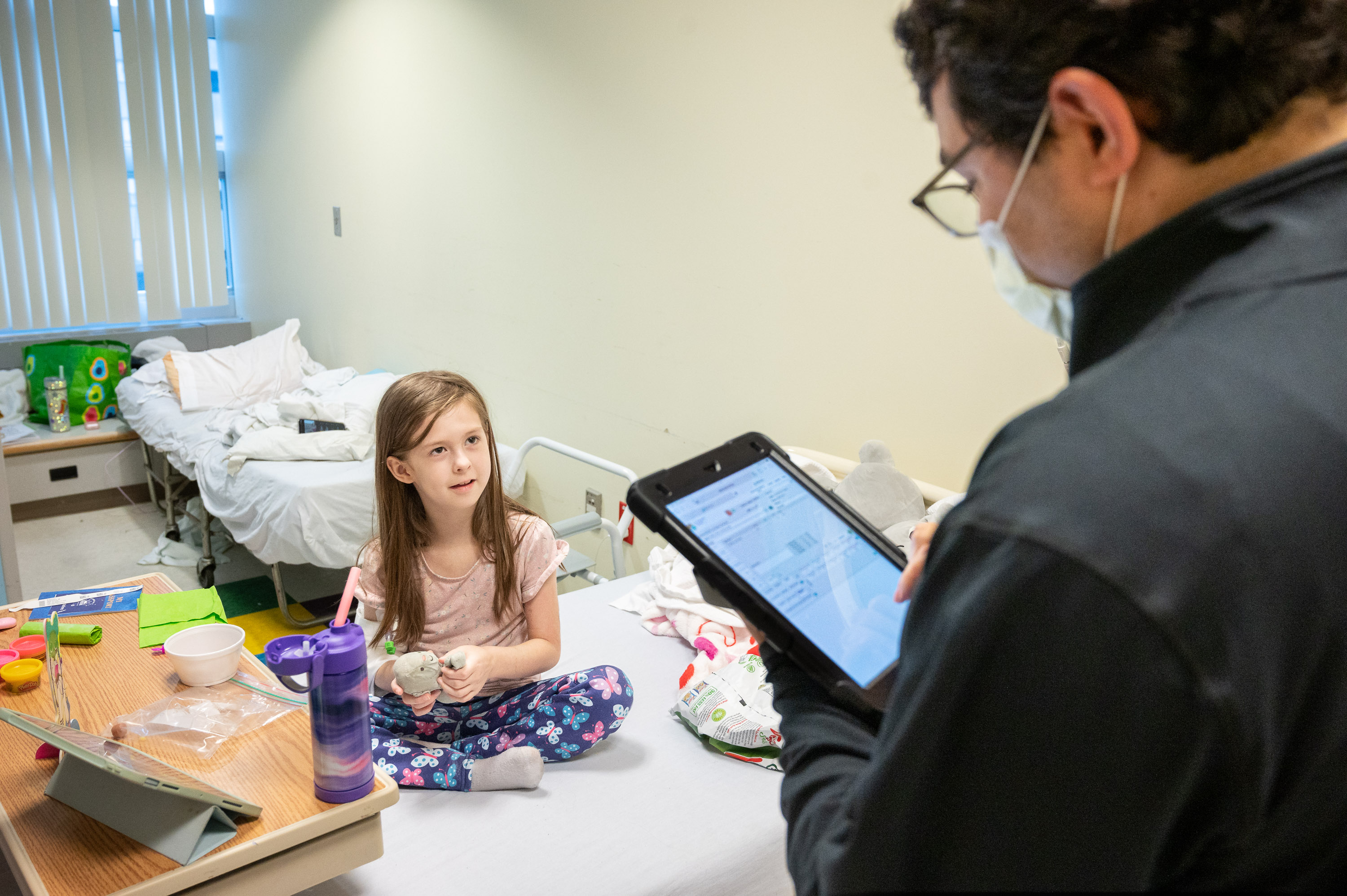 A patient shares her lunch order with a team member who uses a tablet.