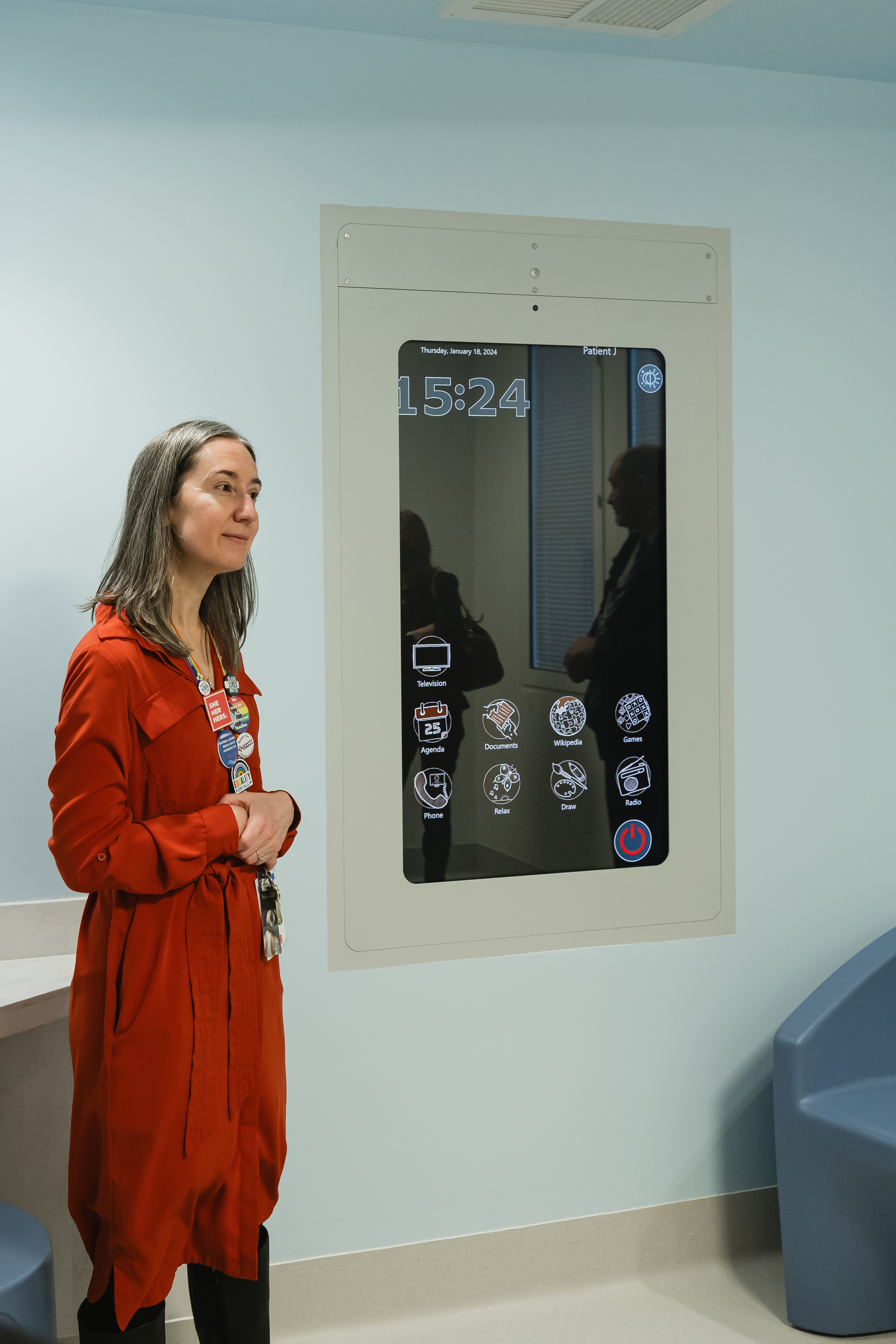 A leader stands in front of the CoWin Media Wall which will aid in entertaining and keeping kids safely connected while being cared for.