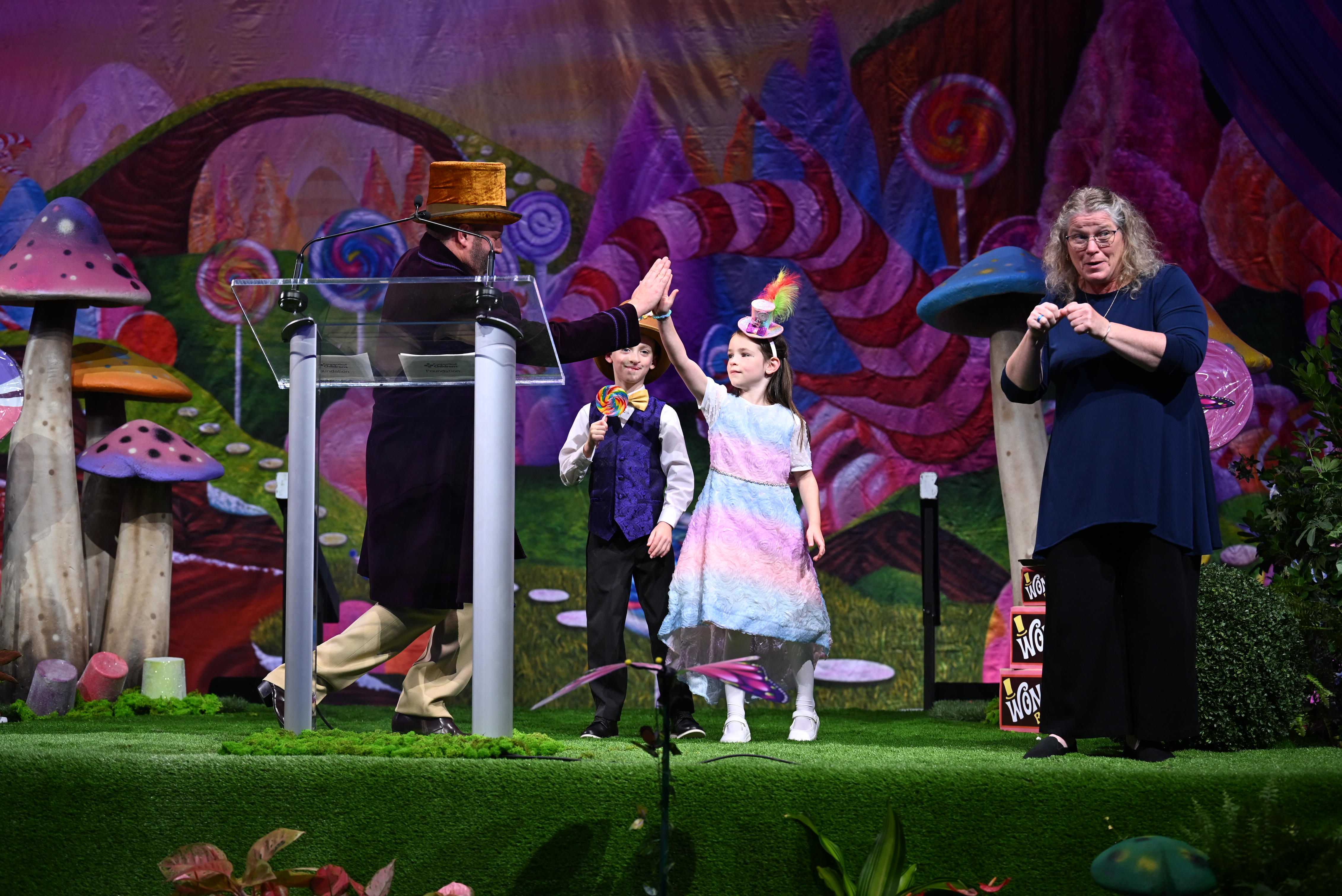 Brent Morin, celebrity emcee, gives a high-five to Candy Kid, Collette.