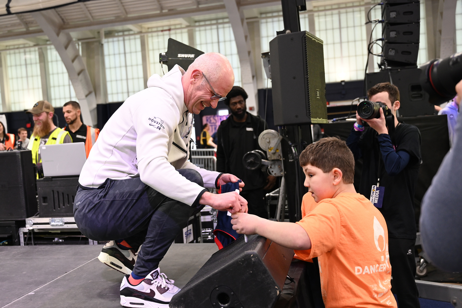 Coach Hurley signs a UCONN Men's Basketball Jersey for an eager Miracle Child.