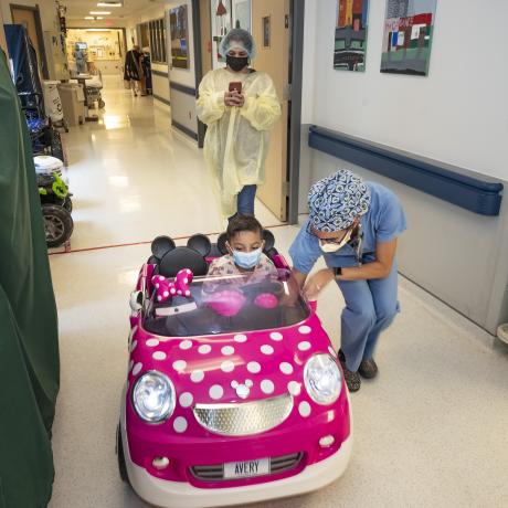 child drives mini mouse car 