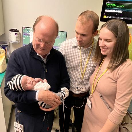 Dr. Crombleholme holding Thaddeus while speaking with parents, Samuel and Ester