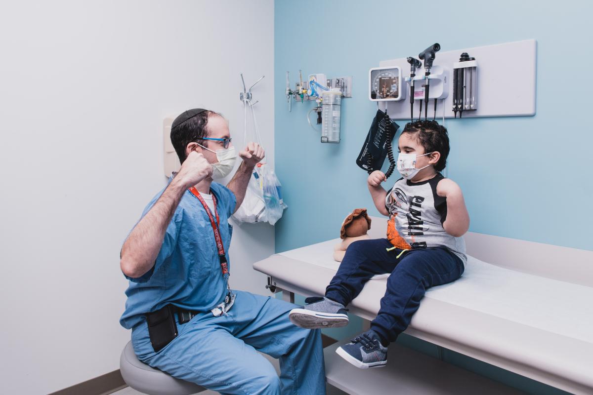 Dr Hersh and young patient flex their muscles