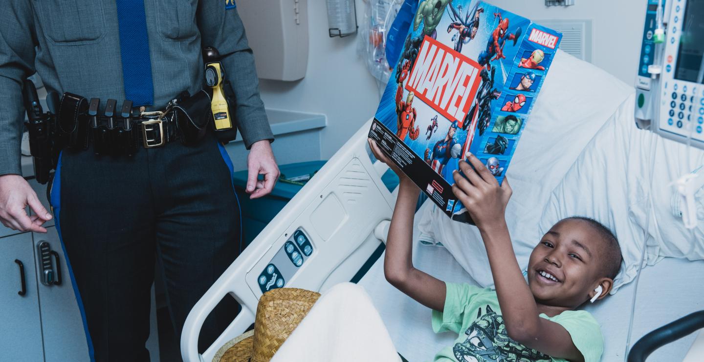 A young boy receives a new toy from Child Life